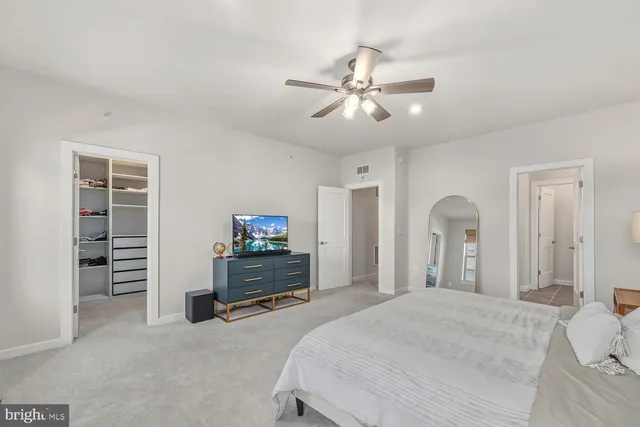 a spacious bedroom with a bed and a chandelier