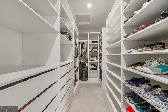 a view of walk in closet with clothes and shoes