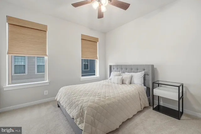 a bedroom with a large bed and a chandelier fan