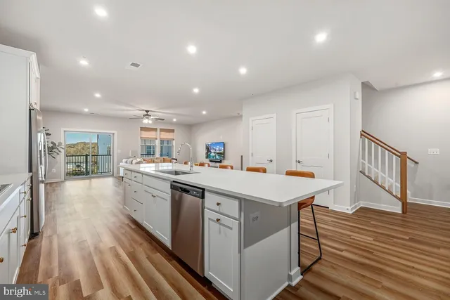 a kitchen with a sink and wooden floor