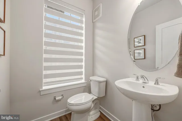 a bathroom with a sink toilet and a mirror