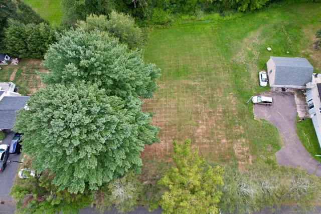 an aerial view of residential houses with outdoor space and trees