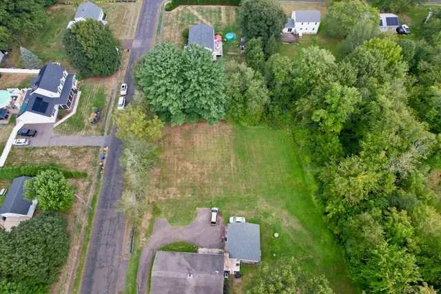 an aerial view of residential house with outdoor space and trees all around
