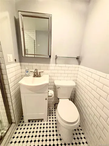 a bathroom with a toilet a sink and a mirror