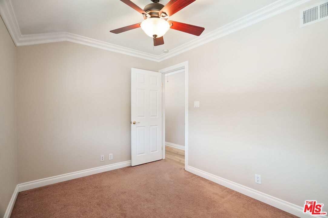 1043 Appleton Road Simi Valley, CA 93065 - Photo 29 of 53 an empty room with a ceiling fan and wooden floor