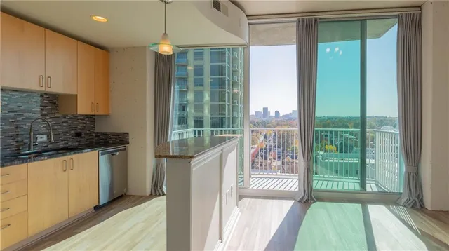 a kitchen with kitchen island a large window cabinets a sink and stainless steel appliances