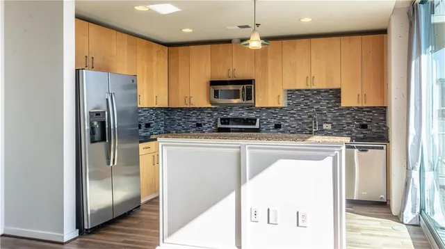 a kitchen with stainless steel appliances granite countertop a refrigerator and a sink