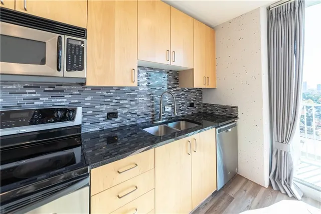 a kitchen with granite countertop a sink stove and cabinets