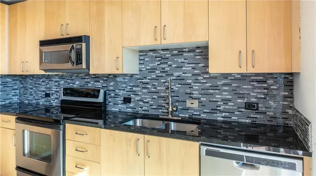 a kitchen with granite countertop a sink stove and cabinets