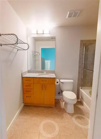 a bathroom with a granite countertop sink mirror vanity and toilet