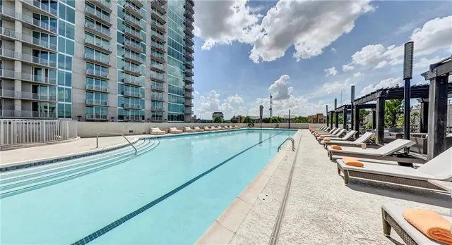 a view of swimming pool with outdoor seating and city view