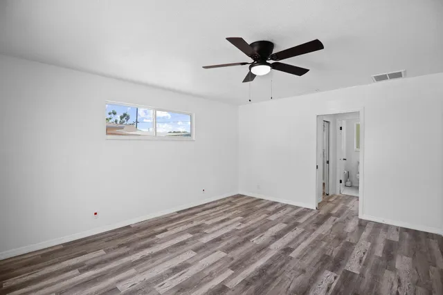 a view of a big room with wooden floor and windows