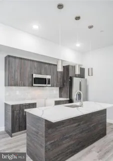a kitchen with kitchen island stainless steel appliances a sink and cabinets