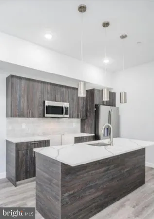 a kitchen with kitchen island stainless steel appliances a sink and cabinets