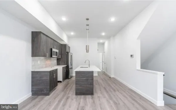 a hallway with wooden floor and staircase