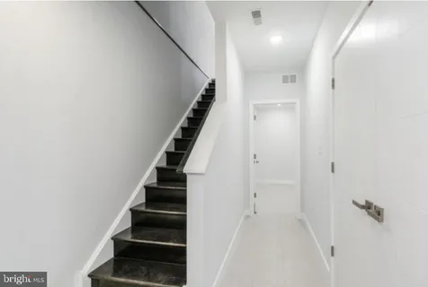 wooden floor in an empty room with a staircase