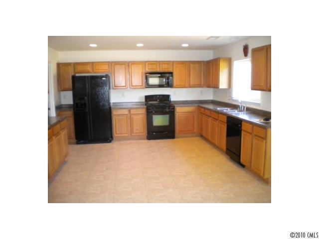 7809 Kuck Road Mint Hill, NC 28227 - Photo 3 of 10 a kitchen with a refrigerator and a sink