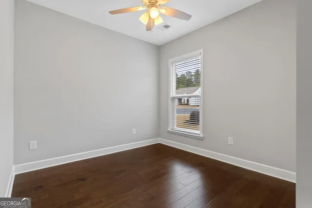 a view of an empty room with wooden floor