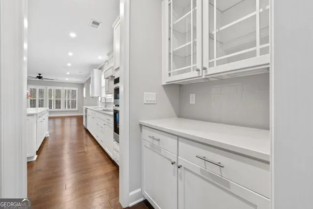 a view of a kitchen with cabinets and wooden floor