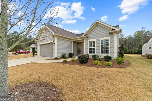 a view of a house with a yard and potted plants