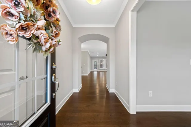 a view of a hallway with wooden floor and a potted plant