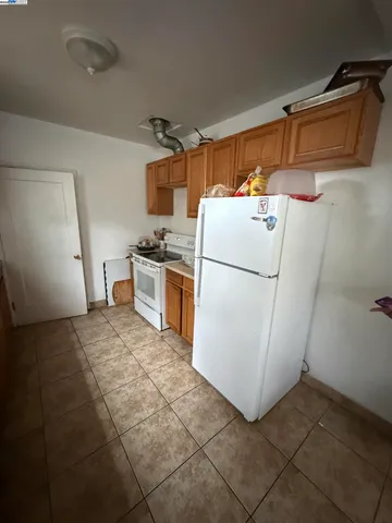 a kitchen with a refrigerator and white cabinets