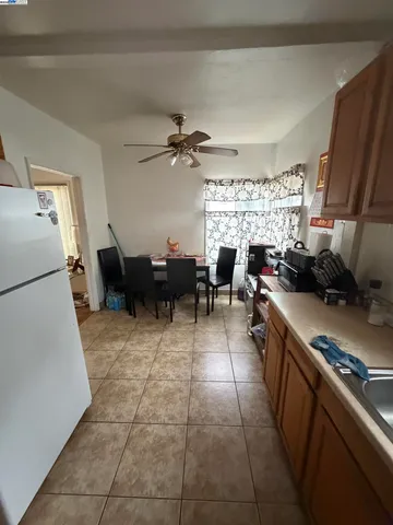 a kitchen with furniture a refrigerator and a view of living room
