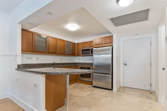 a kitchen with stainless steel appliances granite countertop a refrigerator and a sink