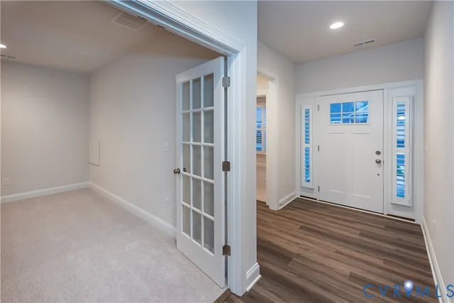an empty room with wooden floor and stairs