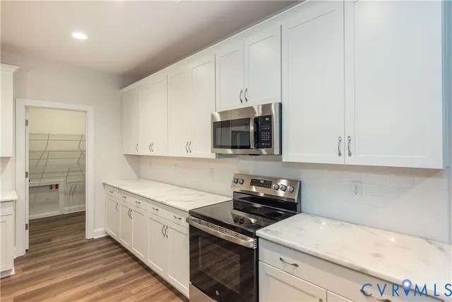a kitchen with stainless steel appliances white cabinets and a sink