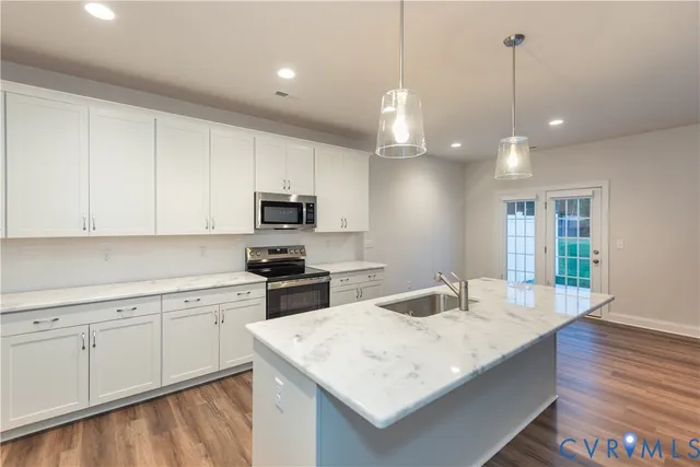 a kitchen with sink cabinets and wooden floor