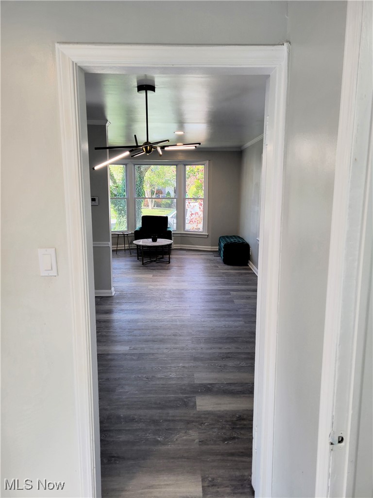 1685 Oakmount Road Cleveland, OH 44121 - Photo 8 of 23 Hall with ornamental molding, a chandelier, and dark wood-type flooring