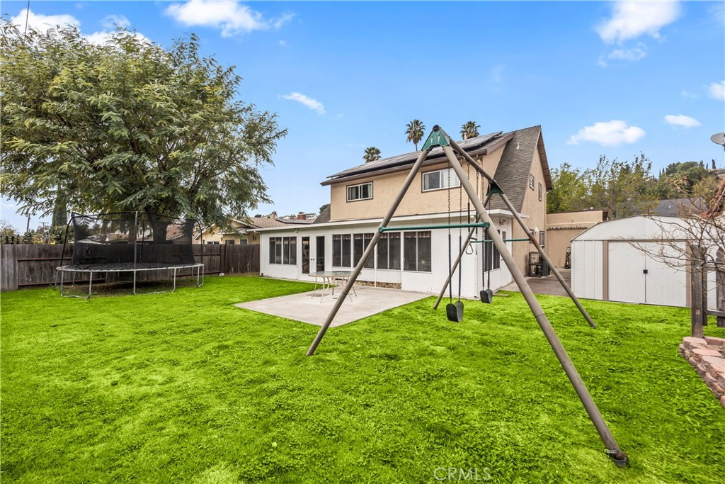a view of a house with backyard and trees