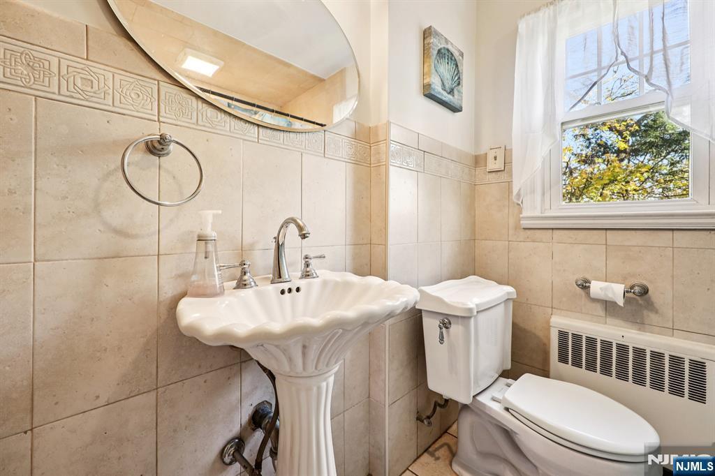 190 Bell Street Belleville, NJ 07109 - Photo 11 of 21 a bathroom with a sink a toilet and a mirror