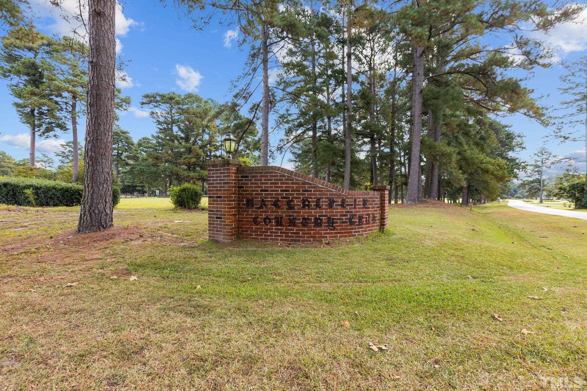 84 Golf Course Drive Pinetops, NC 27864 - Photo 25 of 38 a backyard of a house with large trees and outdoor seating