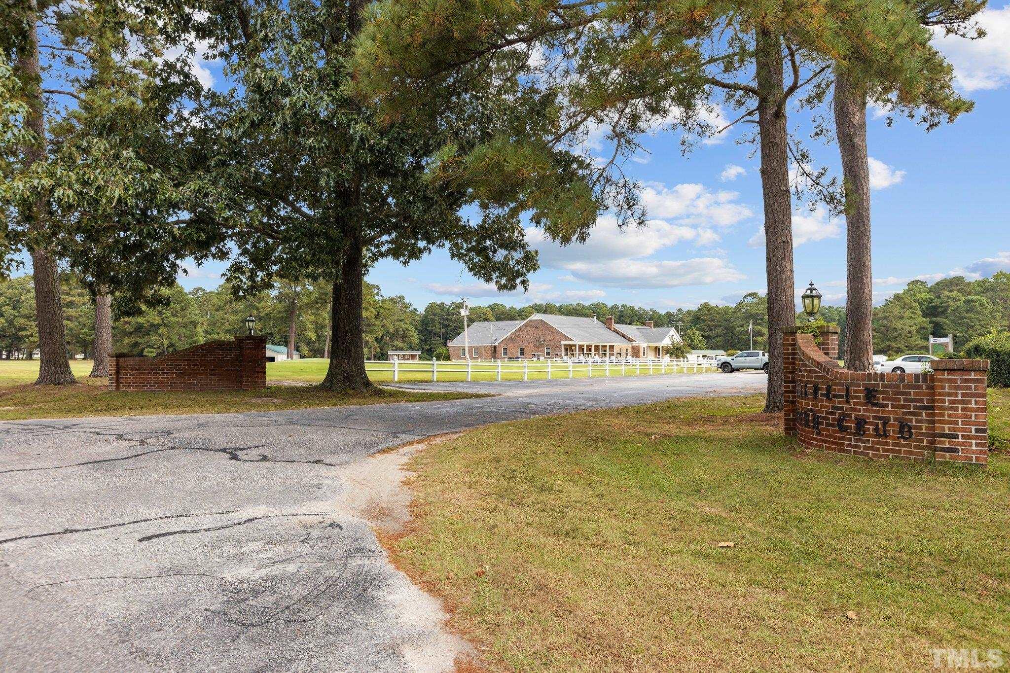 84 Golf Course Drive Pinetops, NC 27864 - Photo 26 of 38 a view of a swimming pool with lawn chairs and a fire pit