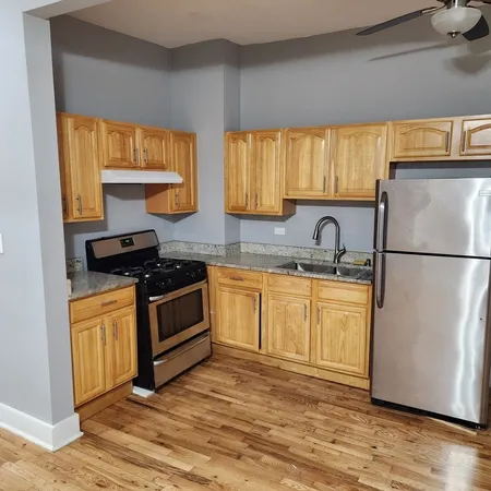 a kitchen with granite countertop a refrigerator sink and cabinets
