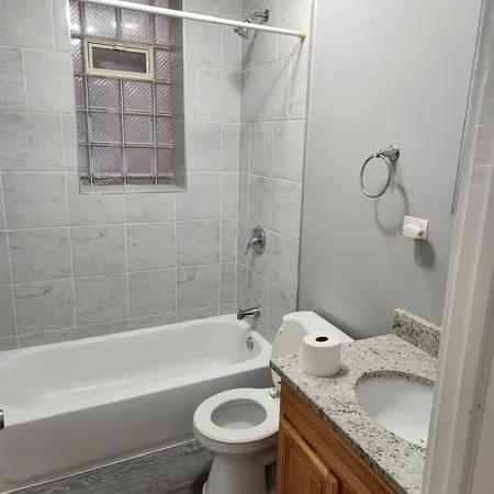 a bathroom with a granite countertop sink toilet and bathtub