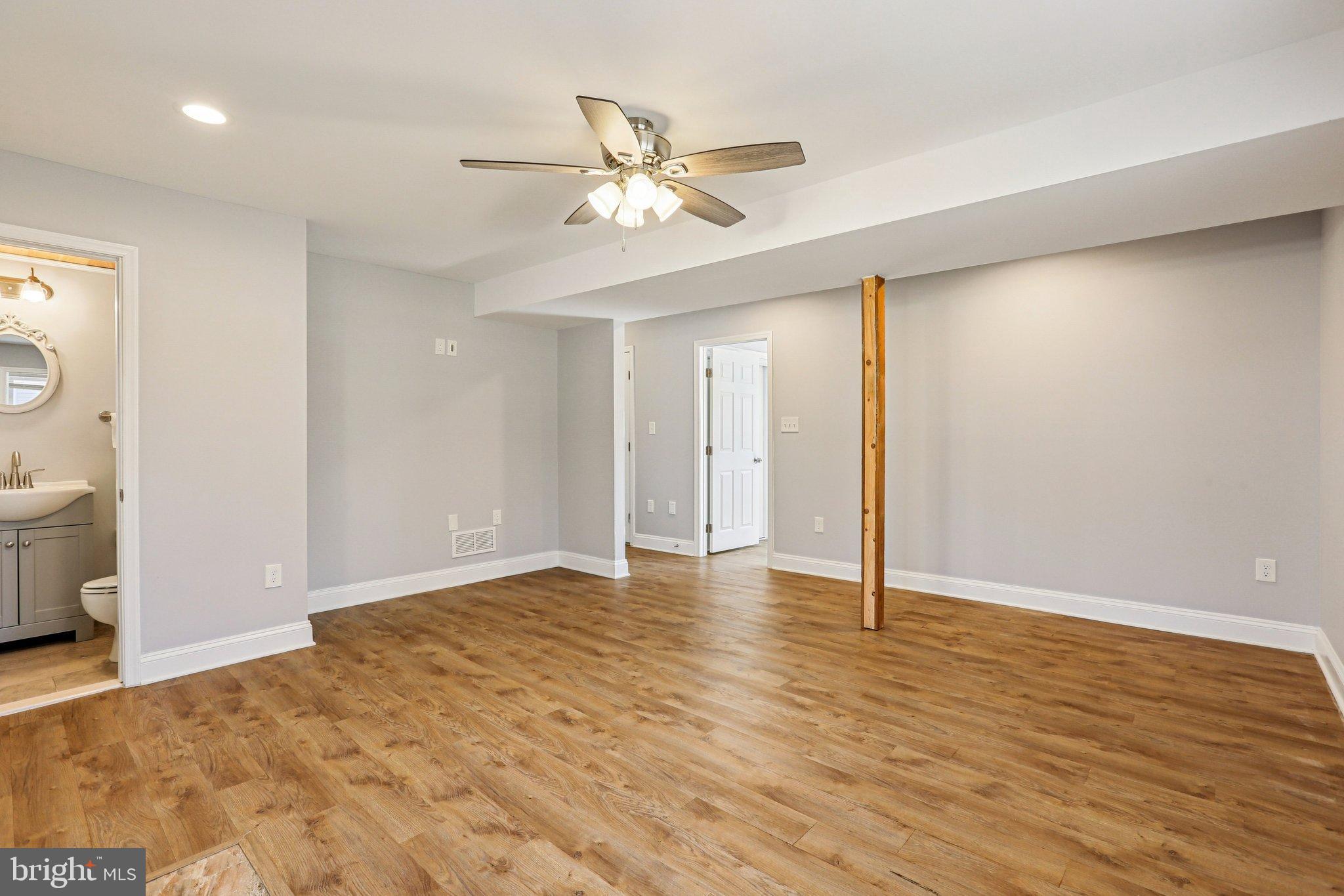 306 Christy Road Pasadena, MD 21122 - Photo 22 of 58 a view of an empty room with wooden floor and a ceiling fan