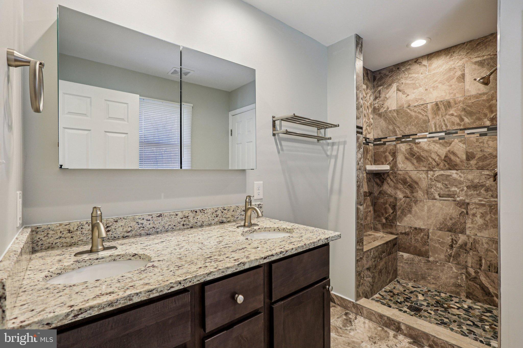 306 Christy Road Pasadena, MD 21122 - Photo 26 of 58 a bathroom with a granite countertop sink a shower and a mirror