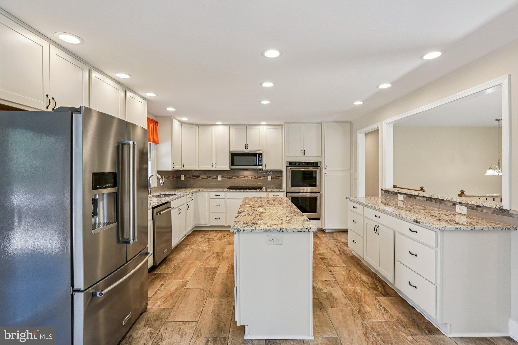306 Christy Road Pasadena, MD 21122 - Photo 9 of 58 a large kitchen with stainless steel appliances kitchen island a stove a sink a refrigerator and a counter top space