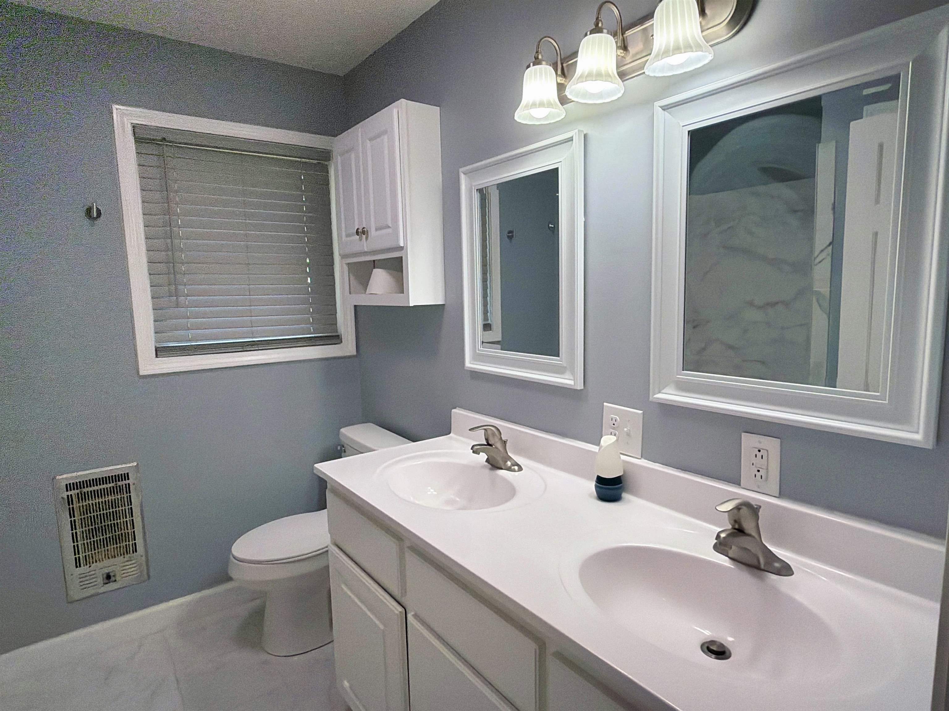 8022 45th Highway Ramer, TN 38367 - Photo 9 of 21 Dual vanity with integrated sinks, white cabinetry, and framed mirrors