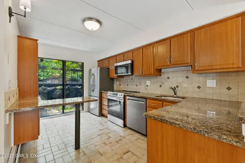 a kitchen with granite countertop a stove a sink and a microwave