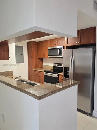 a kitchen with stainless steel appliances granite countertop a sink and a refrigerator