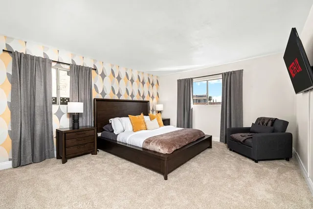 a bedroom with a bed flat screen tv and window