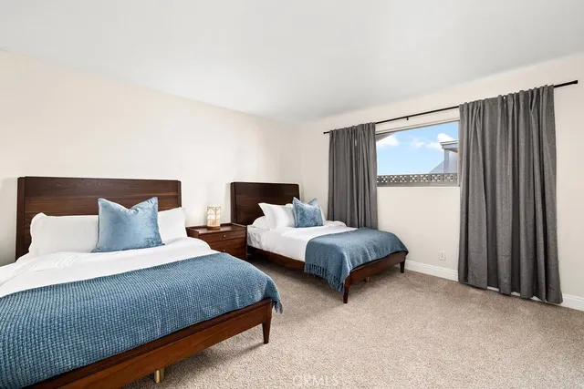 a bedroom with two beds and painting on the wall