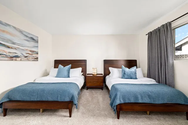 a bedroom with two beds and window