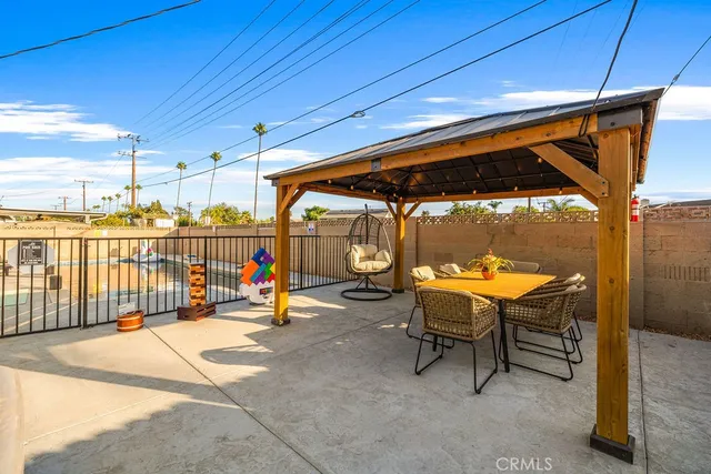 a view of a swimming pool with a patio and a backyard