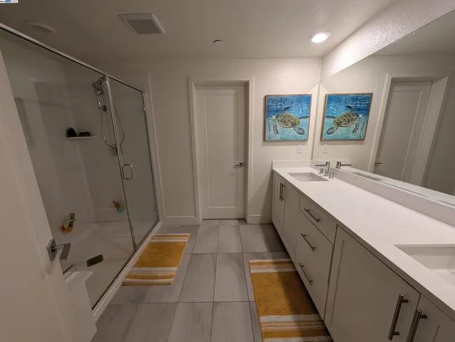 a bathroom with a tub sink shower and mirror