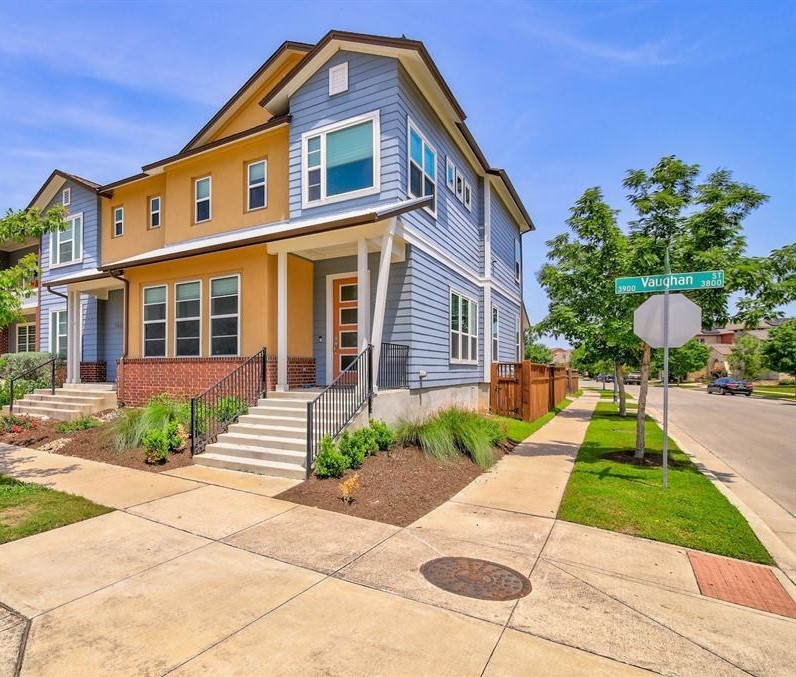 a front view of a house with a yard and potted plants